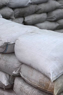 Birçok kirli kum torbası sel savunma için arka plan. Askerî kullanıma yönelik koruyucu kum torbası barikat. Yakışıklı taktik sığınak