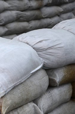 Birçok kirli kum torbası sel savunma için arka plan. Askerî kullanıma yönelik koruyucu kum torbası barikat. Yakışıklı taktik sığınak
