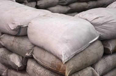 Birçok kirli kum torbası sel savunma için arka plan. Askerî kullanıma yönelik koruyucu kum torbası barikat. Yakışıklı taktik sığınak