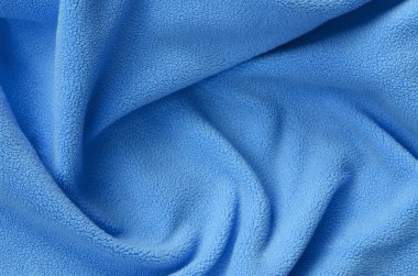 Tüylü mavi Polar kumaş battaniye. Bir arka plan ışık mavi yumuşak peluş Polar malzeme bir sürü kabartma kıvrımları ile