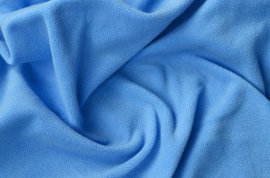 Tüylü mavi Polar kumaş battaniye. Bir arka plan ışık mavi yumuşak peluş Polar malzeme bir sürü kabartma kıvrımları ile