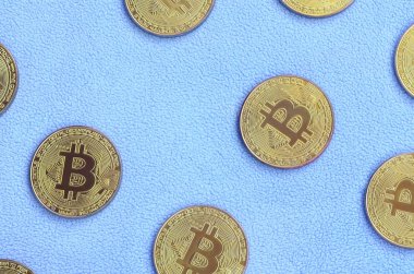 Birçok altın bitcoins yumuşak ve kabarık ışık mavi Polar kumaştan yapılmış bir battaniye yatıyor. Sanal kripto para biriminin fiziksel görselleştirme