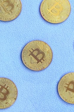 Birçok altın bitcoins yumuşak ve kabarık ışık mavi Polar kumaştan yapılmış bir battaniye yatıyor. Sanal kripto para biriminin fiziksel görselleştirme