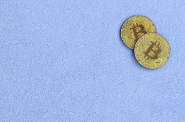 İki altın bitcoins yumuşak ve kabarık ışık mavi Polar kumaştan yapılmış bir battaniye yatıyor. Sanal Kripto para biriminin fiziksel görselleştirme