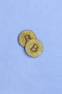 İki altın bitcoins yumuşak ve kabarık ışık mavi Polar kumaştan yapılmış bir battaniye yatıyor. Sanal Kripto para biriminin fiziksel görselleştirme