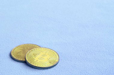 İki altın bitcoins yumuşak ve kabarık ışık mavi Polar kumaştan yapılmış bir battaniye yatıyor. Sanal Kripto para biriminin fiziksel görselleştirme
