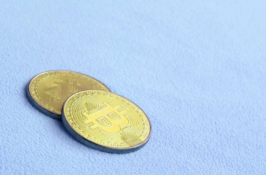 İki altın bitcoins yumuşak ve kabarık ışık mavi Polar kumaştan yapılmış bir battaniye yatıyor. Sanal Kripto para biriminin fiziksel görselleştirme