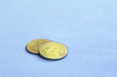 İki altın bitcoins yumuşak ve kabarık ışık mavi Polar kumaştan yapılmış bir battaniye yatıyor. Sanal Kripto para biriminin fiziksel görselleştirme