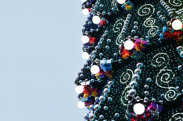 Birçok süsler, hediye kutuları ve aydınlık lambalar ile büyük bir Noel ağacı parçası. Kopya alanı ile dekore edilmiş Noel ağacı yakın çekim fotoğraf