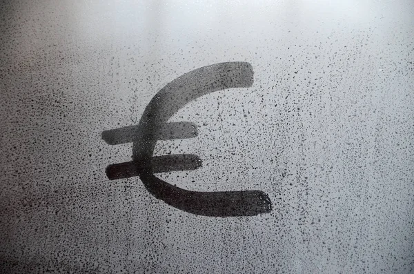 The euro currency symbol on the misted sweaty glass. Abstract background image. Euro currency concept