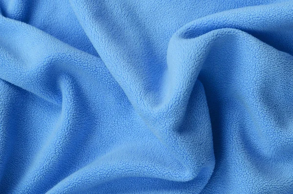 毛茸茸的蓝色羊毛织物的毯子 浅蓝色软毛绒绒材料的背景与大量浮雕褶皱 — 图库照片
