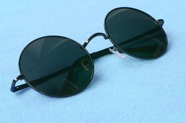 Şık siyah güneş gözlüğü gözlük yalanlar üzerine bir battaniye yumuşak ve kabarık ışık mavi Polar kumaştan yapılmış yuvarlak. Kadın renklerde şık arka plan resmi
