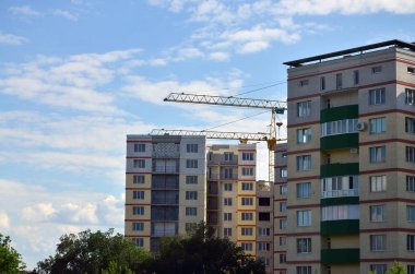 Uzun boylu ve ağır inşaat mavi gökyüzü karşı kule vinç