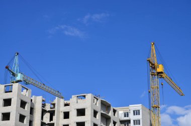 Uzun boylu ve ağır inşaat mavi gökyüzü karşı kule vinç