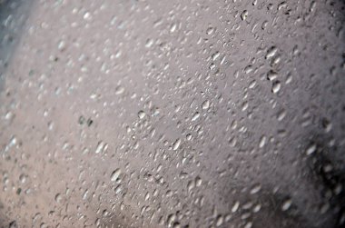 Arka plan resmi yağmur cam pencere üzerinde bırakır. Makro fotoğraf ile sığ derinlik-in tarla