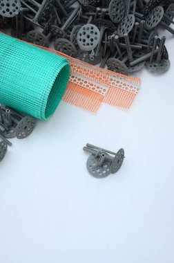 Duvar yalıtım inşaat öğeleri kümesi. Plastik dübeller, bir rulo kafes cepheler ve köşe profili bir kılavuz ile yalıtım için yalan polistren köpük yüzeyinde