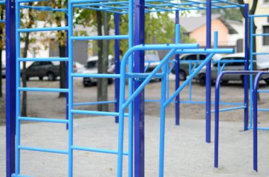 Atletizm eğitimi için arka planda mavi renkli spor barları. Açık havada spor aletleri. Seçici odaklı ve son derece bulanık arkaplanı olan makro fotoğraf