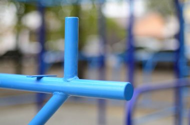 Atletizm eğitimi için arka planda mavi renkli spor barları. Açık havada spor aletleri. Seçici odaklı ve son derece bulanık arkaplanı olan makro fotoğraf