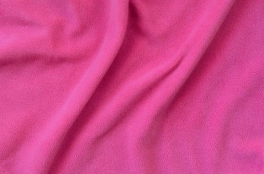 Tüylü pembe Polar kumaş battaniye. Hafif pembe yumuşak peluş Polar malzeme bir sürü kabartma kıvrımları ile bir arka plan