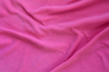 Tüylü pembe Polar kumaş battaniye. Hafif pembe yumuşak peluş Polar malzeme bir sürü kabartma kıvrımları ile bir arka plan