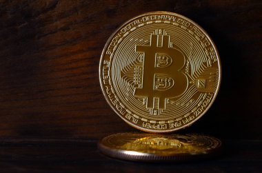 İki yeni altın fiziksel bitcoins yalanlar üzerine koyu ahşap amaç, yakın çekim. Yüksek çözünürlüklü fotoğraf. Cryptocurrency incelemesi kavramı