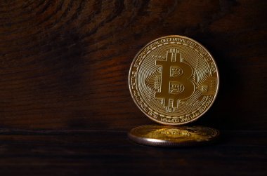 İki yeni altın fiziksel bitcoins yalanlar üzerine koyu ahşap amaç, yakın çekim. Yüksek çözünürlüklü fotoğraf. Cryptocurrency incelemesi kavramı