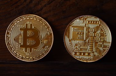İki yeni altın fiziksel bitcoins yalanlar üzerine koyu ahşap amaç, yakın çekim. Yüksek çözünürlüklü fotoğraf. Cryptocurrency incelemesi kavramı