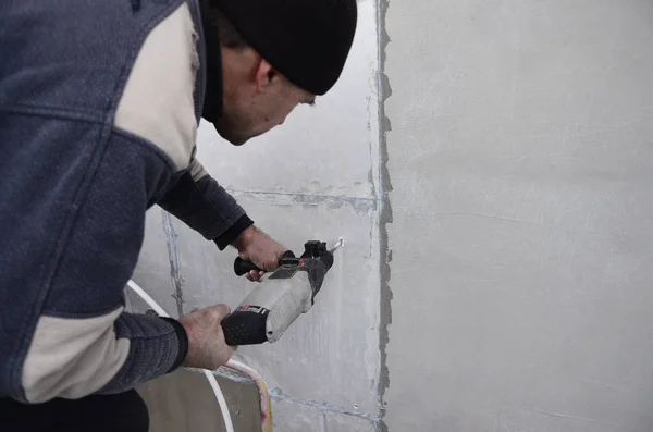 Een Bejaarde Workman Boren Een Gat Een Muur Van Piepschuim — Stockfoto