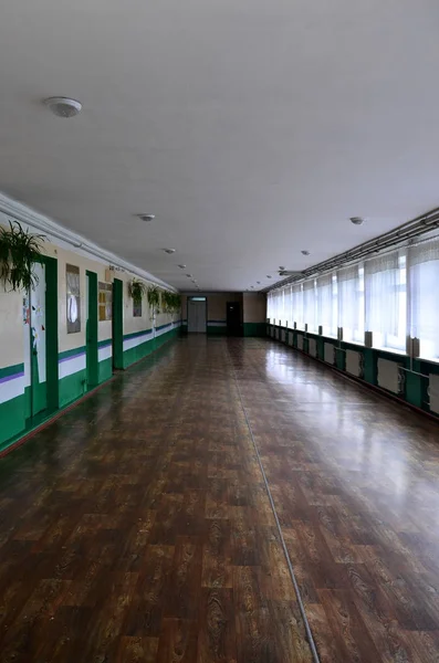 The gloomy corridor of a neglected public building. Public space in a poor residential high-rise building