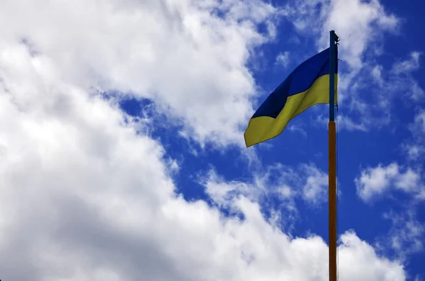 Ukrainian flag against the blue sky with clouds. The official flag of the Ukrainian state includes yellow and blue colors