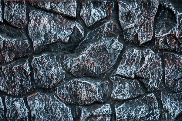 Stone wall background - building feature. Texture of thick and strong wall of rough stones of various shapes and sizes.