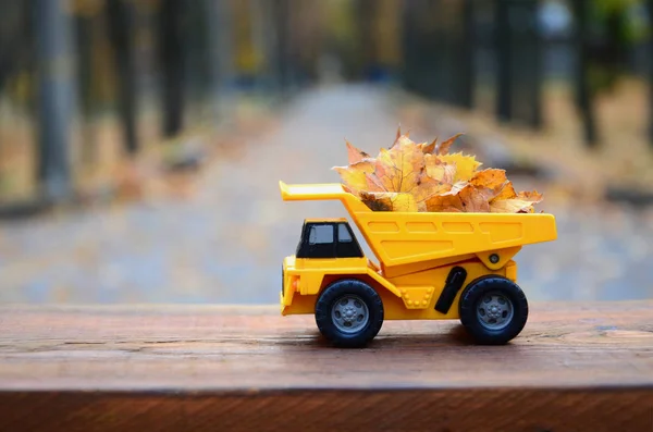 수확의 개념은 잎이을 노란색 장난감 트럭의 형태로 그려져 — 스톡 사진