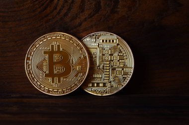 İki yeni altın fiziksel bitcoins yalanlar üzerine koyu ahşap amaç, yakın çekim. Yüksek çözünürlüklü fotoğraf. Cryptocurrency incelemesi kavramı