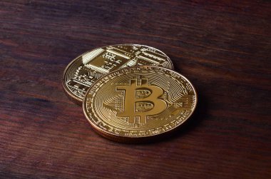 İki yeni altın fiziksel bitcoins yalanlar üzerine koyu ahşap amaç, yakın çekim. Yüksek çözünürlüklü fotoğraf. Cryptocurrency incelemesi kavramı