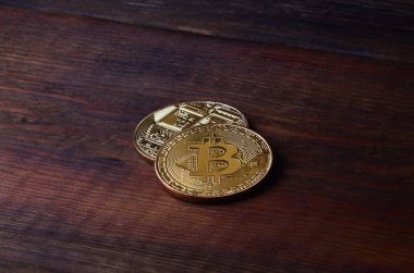 İki yeni altın fiziksel bitcoins yalanlar üzerine koyu ahşap amaç, yakın çekim. Yüksek çözünürlüklü fotoğraf. Cryptocurrency incelemesi kavramı