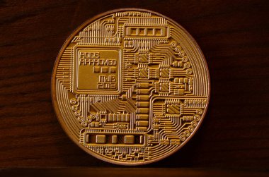 Bir yeni altın fiziksel bitcoin koyu ahşap artalan üzerinde yatıyor, yakın çekim. Yüksek çözünürlüklü fotoğraf. Cryptocurrency incelemesi kavramı