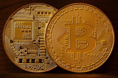 İki yeni altın fiziksel bitcoins yalanlar üzerine koyu ahşap amaç, yakın çekim. Yüksek çözünürlüklü fotoğraf. Cryptocurrency incelemesi kavramı