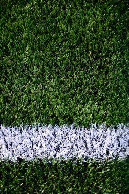 Parlak yeşil yeşil çimen futbol sahasında beyaz şerit.