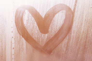 Yağmurlu havalarda misted camına bir parmak tarafından çizilmiş bir kalp şeklinde çizim