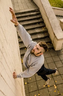 Genç bir adam üzerinde beton duvarlar tırmanma engeller, üstesinden gelir. Sokak koşullarda eğitim atlet uygulamaları parkour. Spor altkültürler gençler arasında kavramı