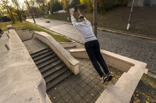 Młody Facet Wykonuje Skok Przez Przestrzeń Między Parapety Betonowe Sportowiec — Zdjęcie stockowe