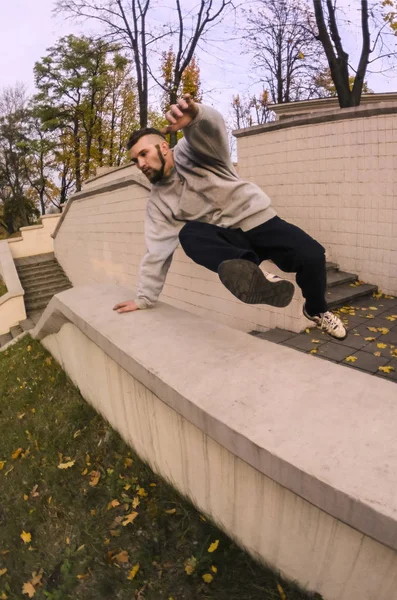 Młody Facet Wykonuje Skok Przez Konkretny Parapet Sportowiec Praktyki Parkour — Zdjęcie stockowe