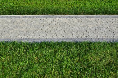 Güzel bir yeni geçit Parke taş yeşil çimlerin arasında yer alır