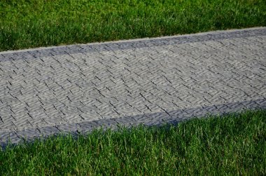 Güzel bir yeni geçit Parke taş yeşil çimlerin arasında yer alır