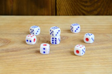 Doğal ahşap yüzey üzerinde birkaç zar yatıyor. Bir altı küpleri yan tarafında boyalı Puan şeklinde numaralarını oluşturmak için öğeleri. Kumar kavramı