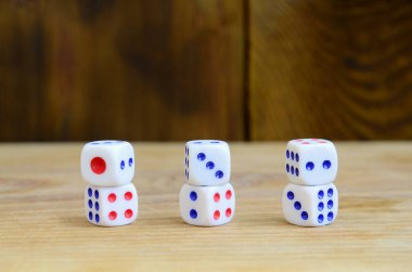 Doğal ahşap yüzey üzerinde birkaç zar yatıyor. Bir altı küpleri yan tarafında boyalı Puan şeklinde numaralarını oluşturmak için öğeleri. Kumar kavramı