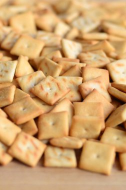 Küçük kurabiye çok kare şeklinde. Sarı tuzlu kraker bir model. Arka plan görüntüsü ile tuzlu pasta