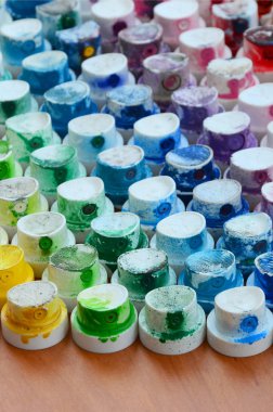 Bir çok farklı renklere bulaşmış grafiti çizim için bir boya püskürtme başlıklarından bir desen. Plastik kapaklar gökkuşağı rengi oluşturan birçok satır düzenlenir