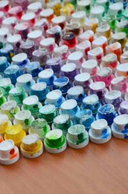 Bir çok farklı renklere bulaşmış grafiti çizim için bir boya püskürtme başlıklarından bir desen. Plastik kapaklar gökkuşağı rengi oluşturan birçok satır düzenlenir