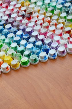 Bir çok farklı renklere bulaşmış grafiti çizim için bir boya püskürtme başlıklarından bir desen. Plastik kapaklar gökkuşağı rengi oluşturan birçok satır düzenlenir